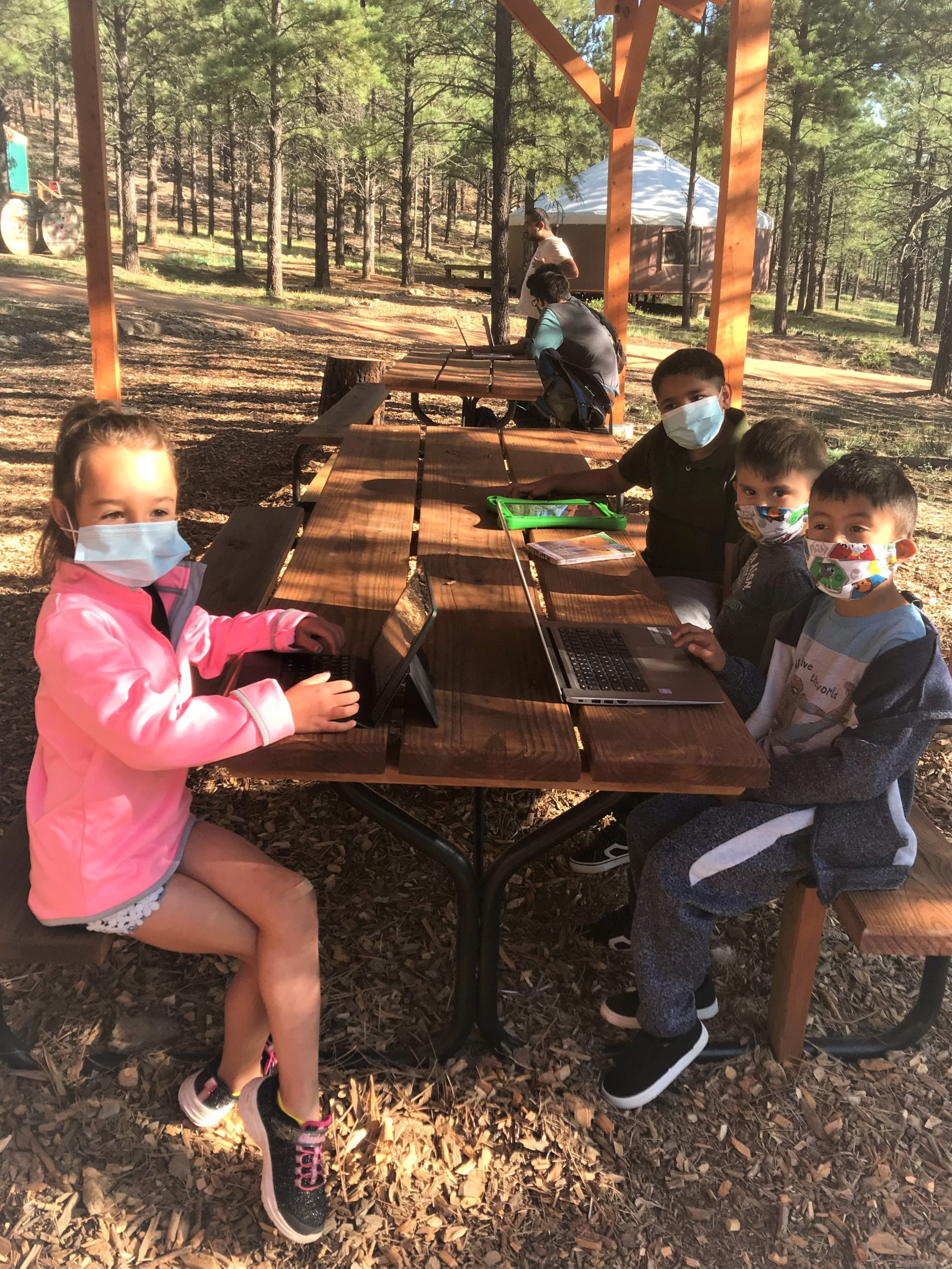 Image shows children in outdoor classroom setting.