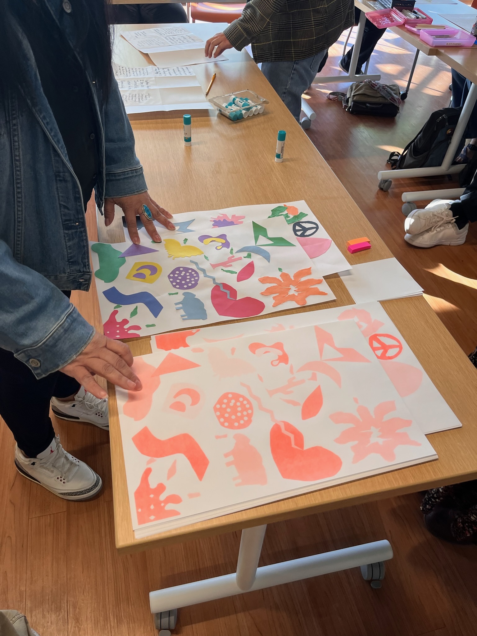 A close up of some of the graphics participants have created.  A person's hands are touching the artwork.